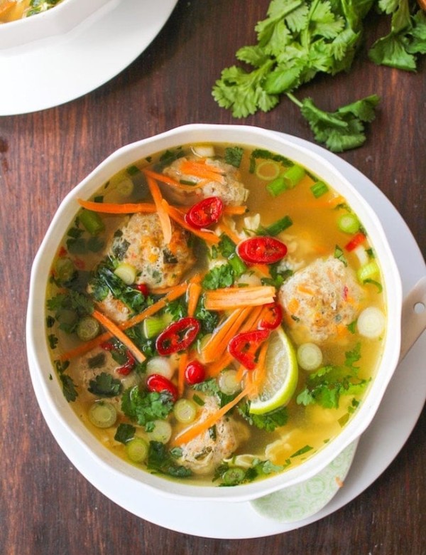 Thai-Meatball-Soup in a white bowl surrounded by cilantro