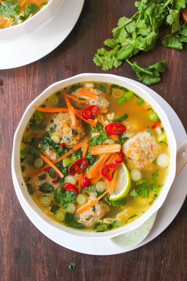 Thai-Meatball-Soup in a white bowl surrounded by cilantro