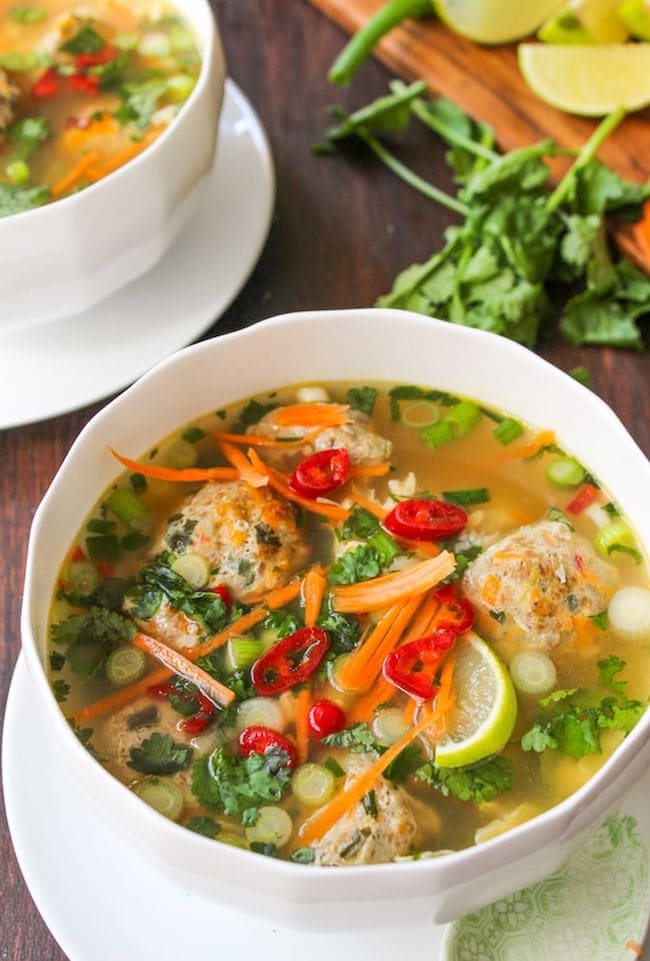 Thai-Meatball-Soup in a white bowl surrounded by cilantro