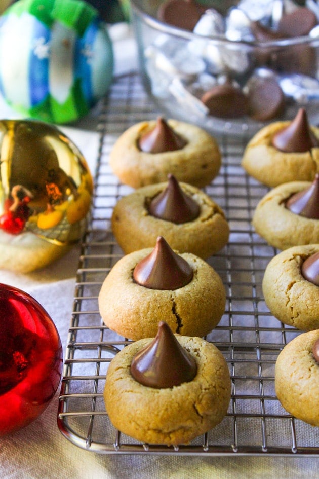 Gluten Free Peanut Butter Blossom on a cooling rack next to christmas baubles 