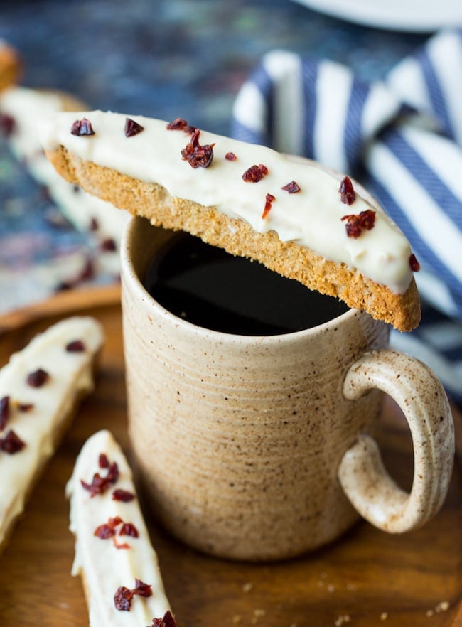 cranberry bliss gluten free biscotti sitting on top of cup of coffee