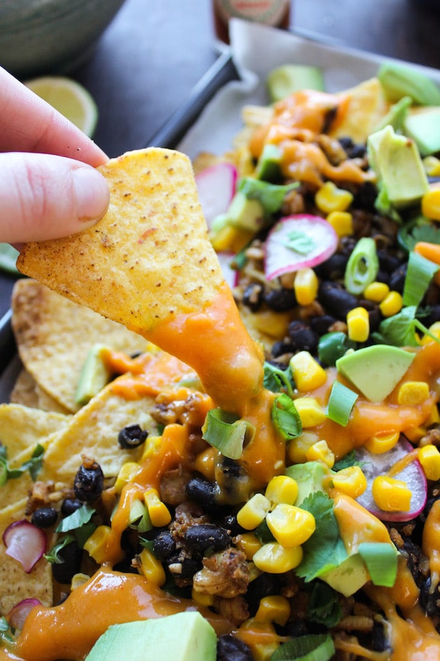 Easy, cheesy, plant based Vegan Nachos loaded with veggies, stretchy nacho cheese, and a black bean-walnut 'meat'. Gluten Free + Dairy Free