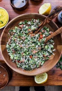 Paleo Cauliflower Tabbouleh in a wooden bowl with salad spoons