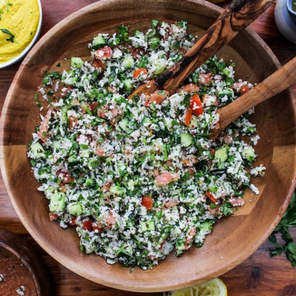 Paleo Cauliflower Tabbouleh in a wooden bowl with salad spoons