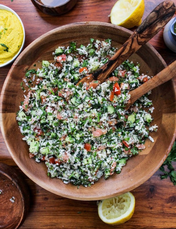 Paleo Cauliflower Tabbouleh in a wooden bowl with salad spoons