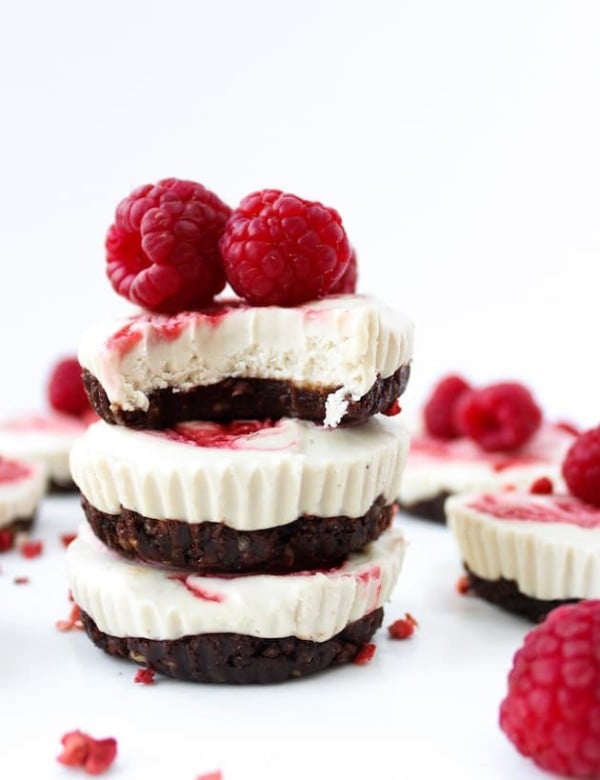 Raspberry Swirl Raw Cheesecake Cups stacked with raspberries on top