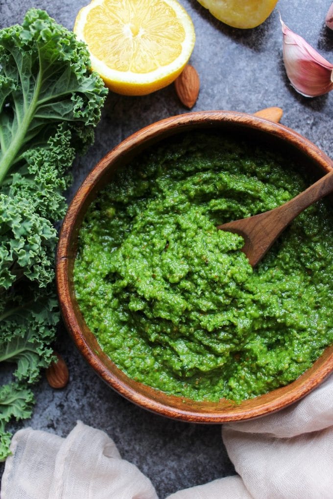 kale pesto in a bowl next to a rib of kale