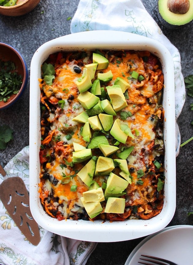 Spiralized Sweet Potato Enchilada Casserole topped with avocado, spring onion and cilantro 