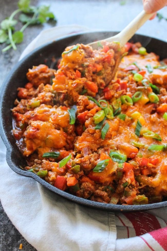 one pot taco skillet in a cast iron skillet with a spoon scooping it up