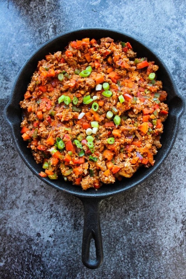 one pot taco skillet in a cast iron skillet topped with green onions 