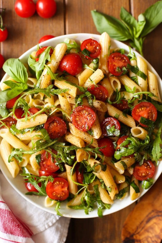 a serving bowl full of Tomato & Arugula Balsamic Pasta Salad