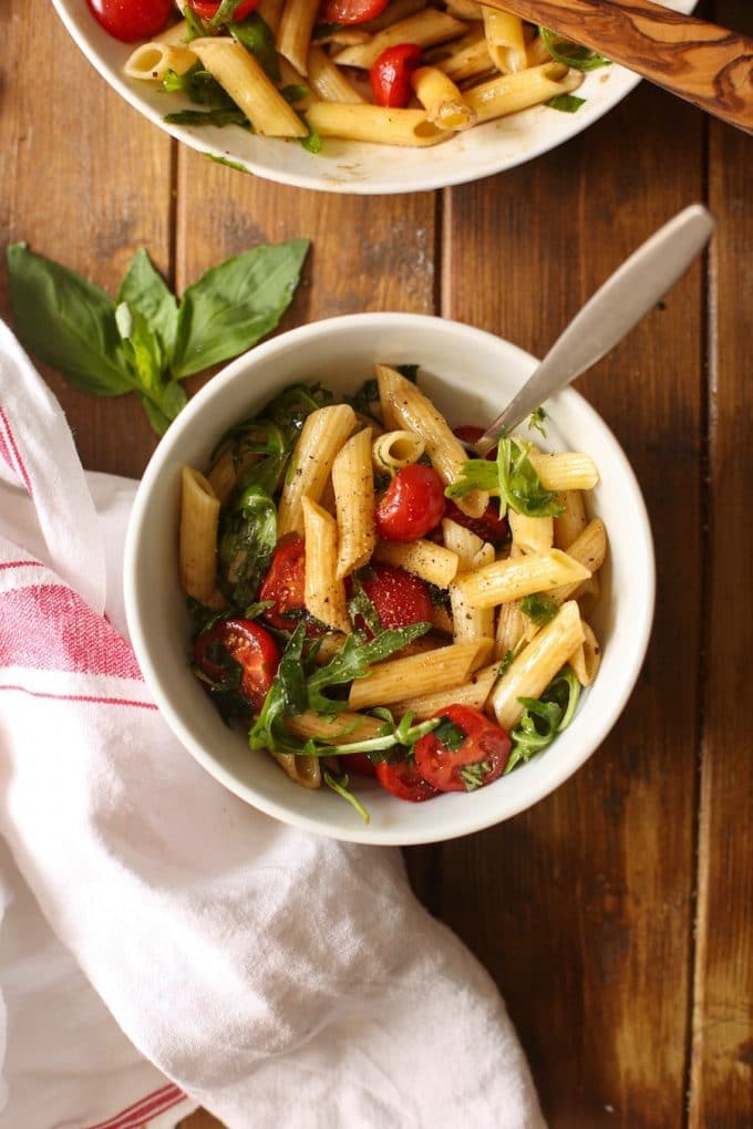 a small serving bowl full of Tomato & Arugula Balsamic Pasta Salad