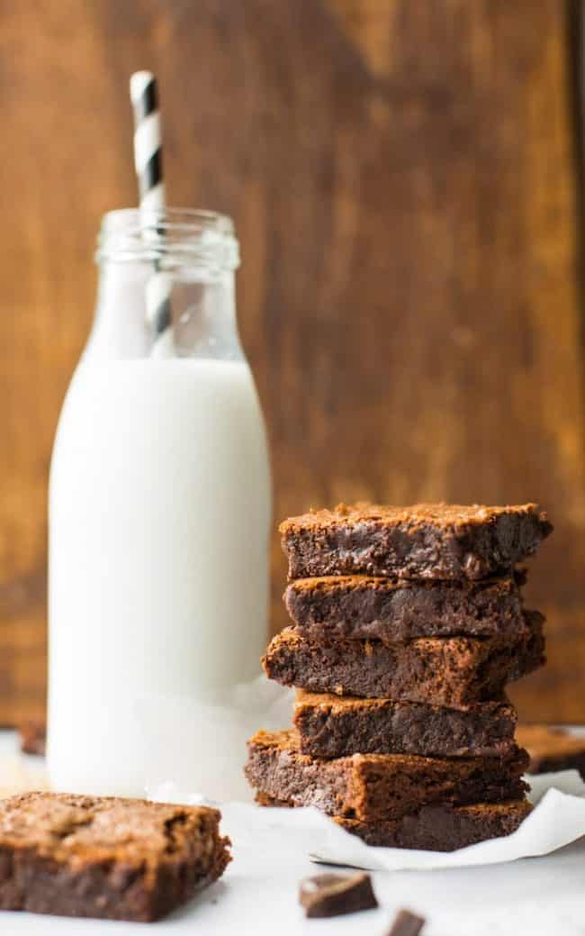 paleo brownies stacked with a glass of milk