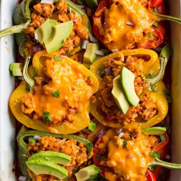 taco stuffed peppers - some topped with cheese and some topped with avocado