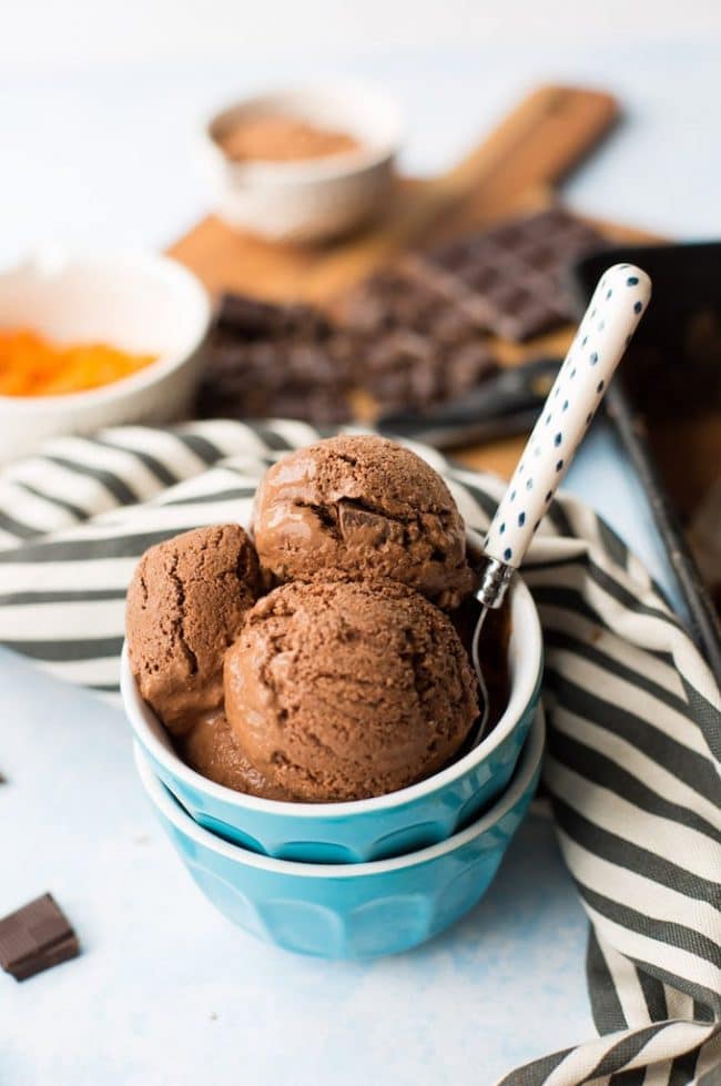 three scoops of chocolate Coconut Milk Ice Cream in a blue bowl with a spoon