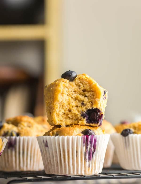 two Gluten Free Blueberry Cornbread Muffins stacked on a cooling rack