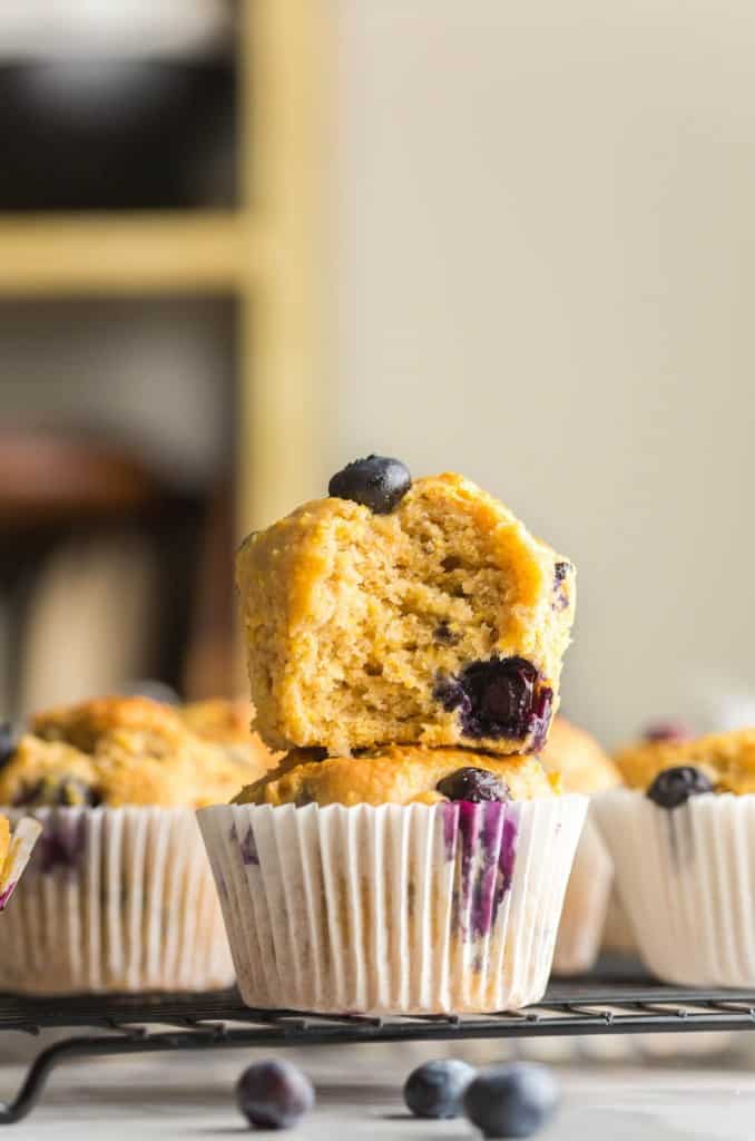 two Gluten Free Blueberry Cornbread Muffins stacked on a cooling rack