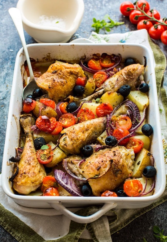 Easy One Pan Greek Chicken with Roasted Veggies in a baking dish with a spoon