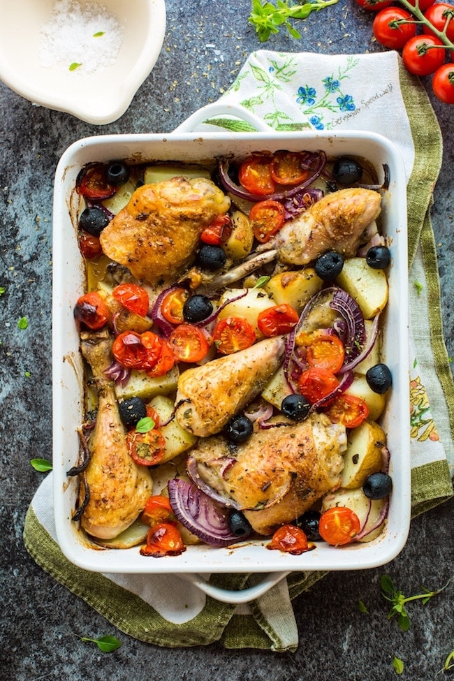 Easy One Pan Greek Chicken with Roasted Veggies in a baking dish on a kitchen napkin 