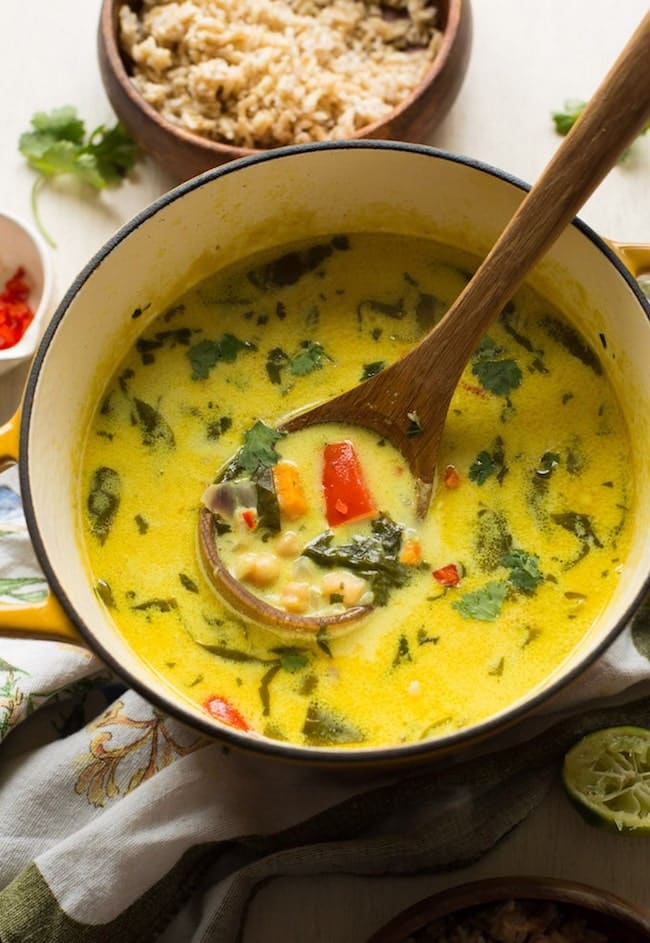 Chickpea Lime & Coconut Soup in a soup pot with a wooden spoon