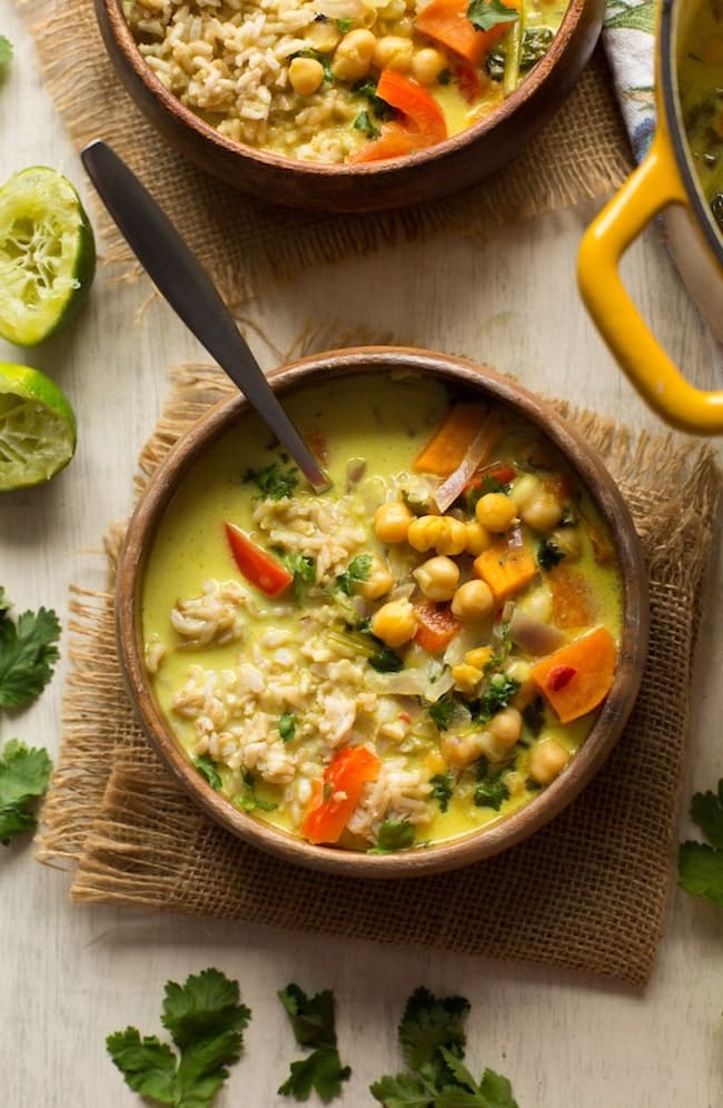 Chickpea Lime & Coconut Soup in a wooden bowl with limes on the side