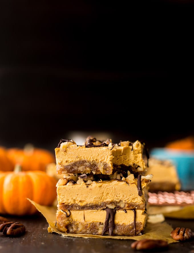 No Bake Pumpkin Cheesecake Bars - A naturally sweetened nut and date crust topped with a creamy cashew and pumpkin cheesecake and sprinkled with crushed pecans and a drizzle of chocolate | Gluten Free + Paleo + Vegan