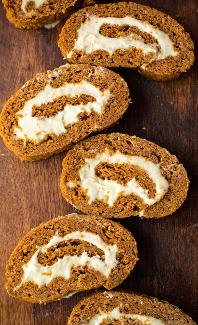 Tender, moist and flavourful Paleo Pumpkin Roll - a light and fluffy almond based cake filled with a simple cashew cream! | Gluten Free + Dairy Free | Sliced cake laying out on chopping board