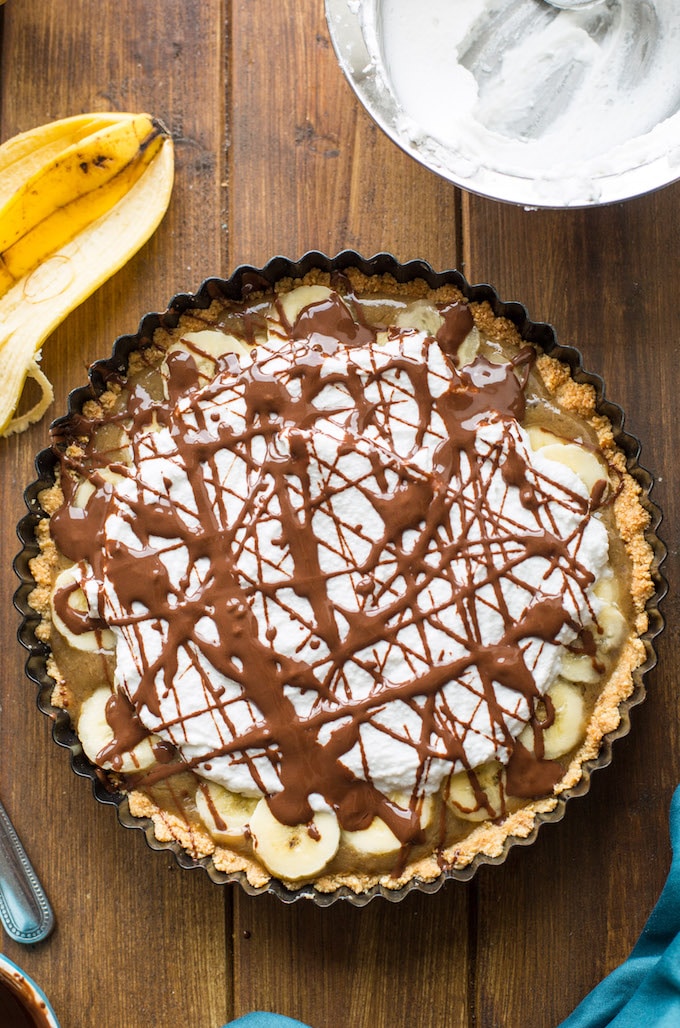 Rich and decedent Vegan Banoffee Pie - a simple, almond flour crust topped with silky caramel, banana, coconut whipped cream and a drizzle of chocolate | Gluten Free + Paleo  