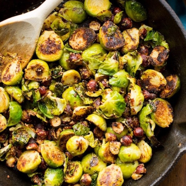 sautéed Brussels sprouts in a cast iron skillet with hazelnuts