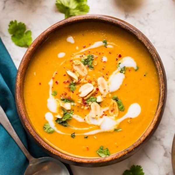 Peanut Carrot & Sweet Potato Soup in a bowl topped with peanuts and coconut cream