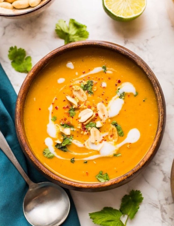 Peanut Carrot & Sweet Potato Soup in a bowl topped with peanuts and coconut cream