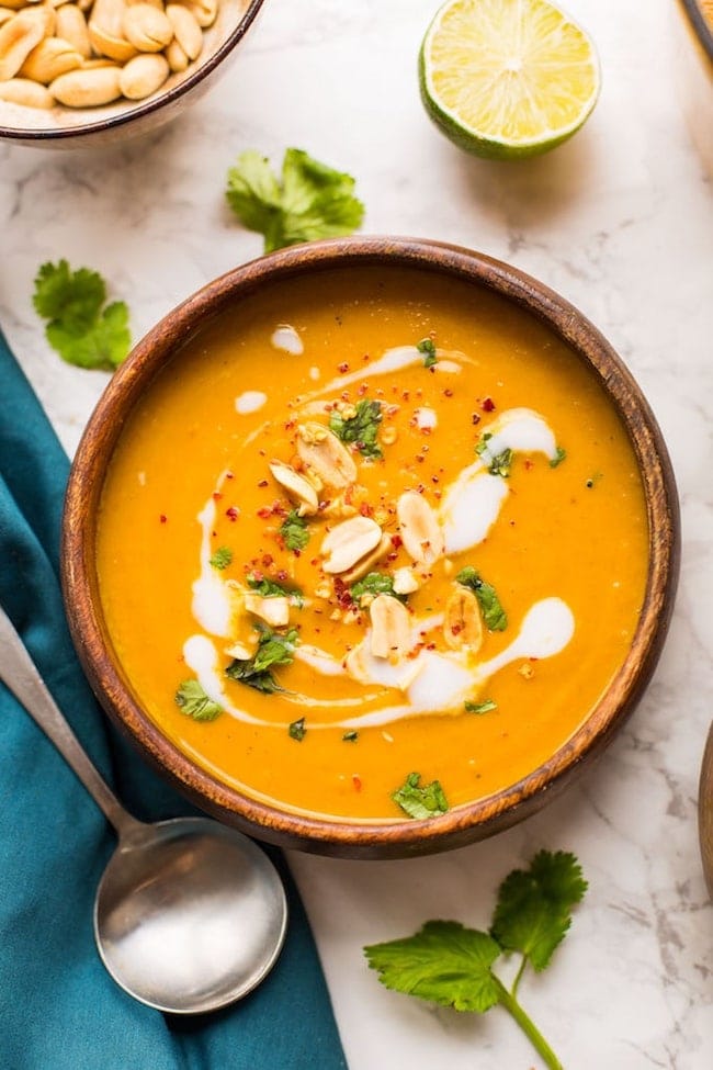 Peanut Carrot & Sweet Potato Soup in a bowl topped with peanuts and coconut cream