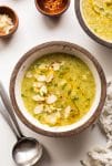 bowl Broccoli Leek Soup topped with sliced almond, chives and red pepper flakes
