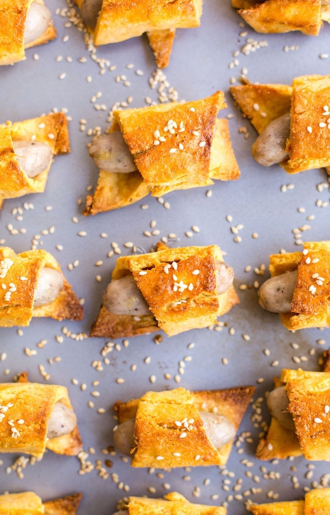 Paleo Pigs in a Blanket with sesame seeds on a baking sheet