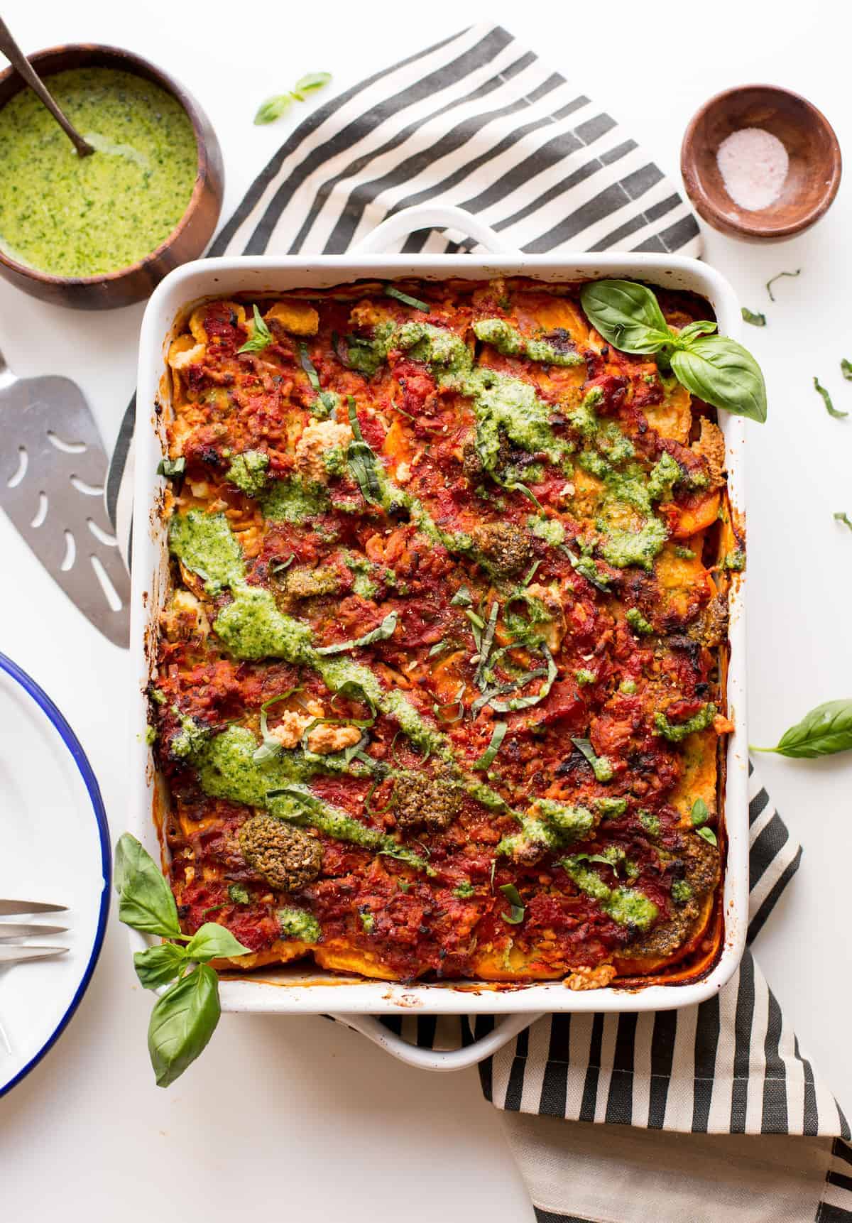 sweet potato lasagna topped with pesto and basil 