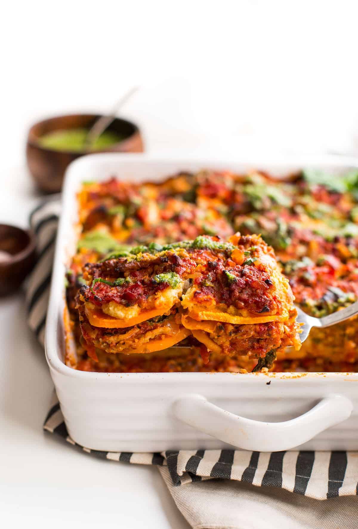 serving spoon holding up paleo sweet potato lasagna 