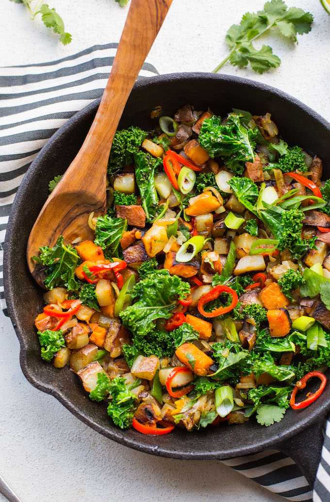  Kale Potato Breakfast Hash in a cast iron skillet with wooden spoon