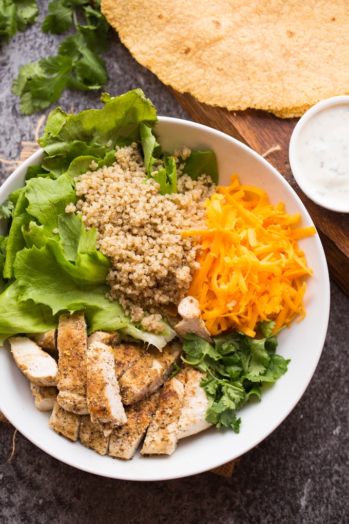 Low FODMAP Quinoa Chicken Ranch Wraps fillings - chopped grilled chicken, butter lettuce, quinoa and cheese in a bowl