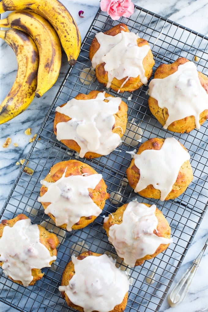  Banana Nut Scones covered in a maple glaze cooling on a wire rack with ripened bananas #gltuenfree #vegan #bananas