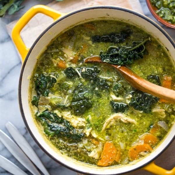 kale & chicken pesto soup in a yellow soup pot with a ladle