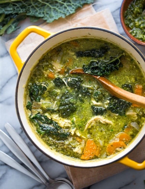 kale & chicken pesto soup in a yellow soup pot with a ladle