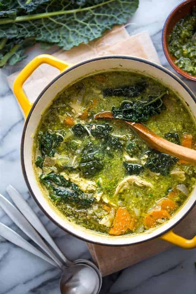 kale & chicken pesto soup in a yellow soup pot with a ladle