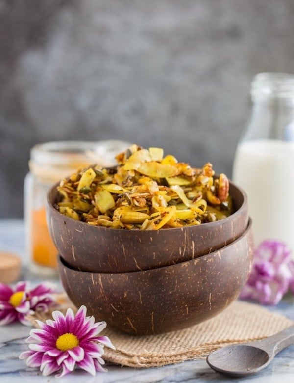 Turmeric & cinnamon spied stove top paleo granola in a cereal bowl surrounded by flowers #glutenfree #paleo #vegan