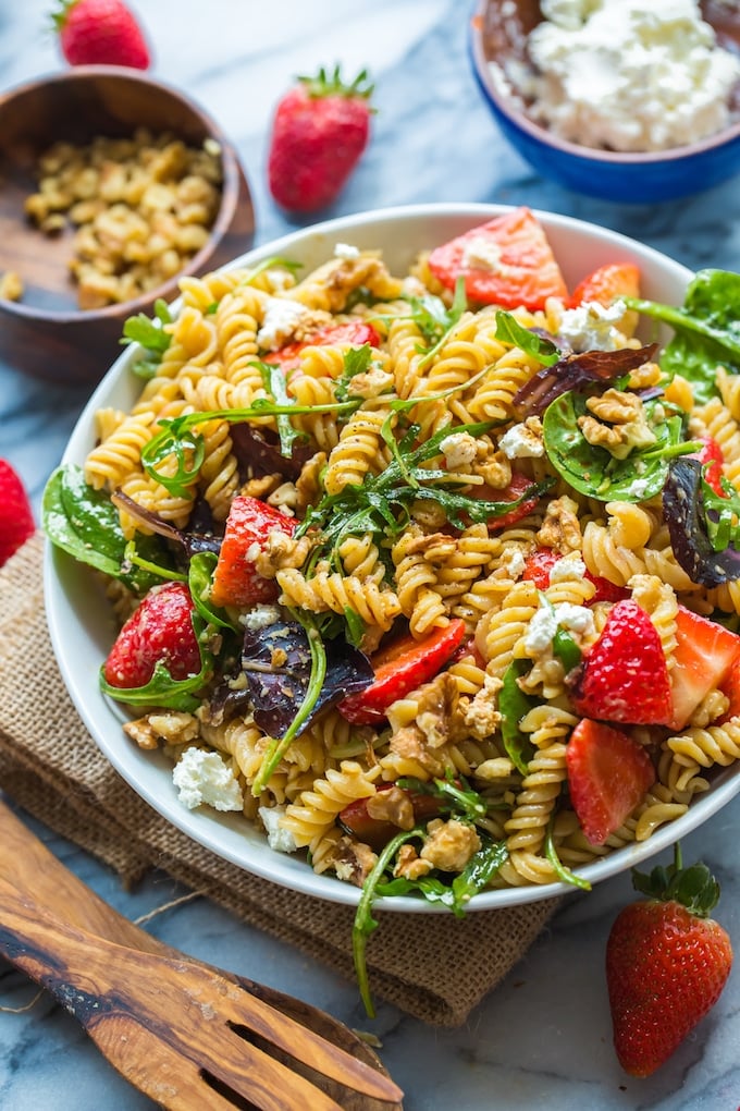 Balsamic Strawberry Pasta Salad in a bowl with salad tongs on the side