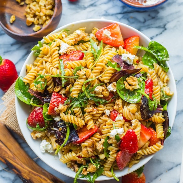 Balsamic Strawberry Pasta Salad in a bowl surrounded by strawberries and feta