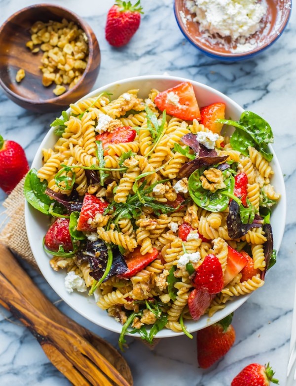 Balsamic Strawberry Pasta Salad in a bowl surrounded by strawberries and feta