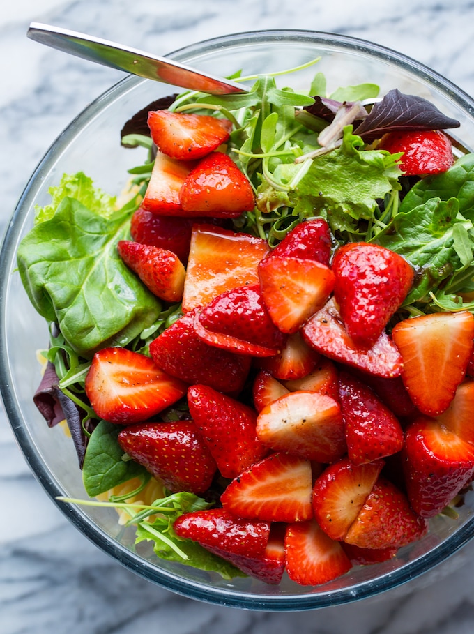 strawberries and salad greens in a bowl