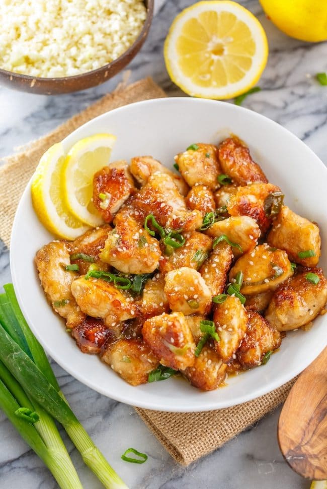 Paleo Chinese Lemon Chicken in a bowl topped with sesame seeds and spring onions