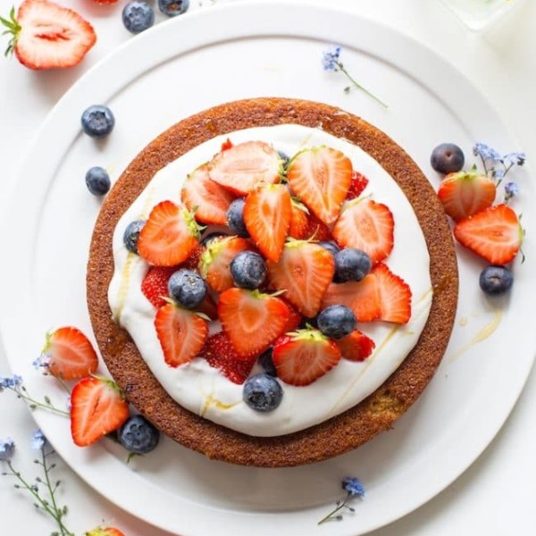 coconut flour cake topped with coconut whipped cream and berries