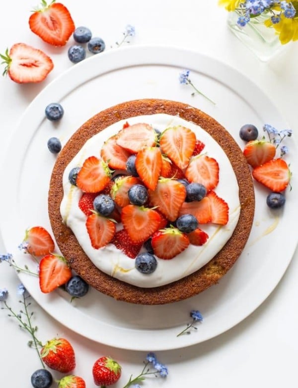 coconut flour cake topped with coconut whipped cream and berries